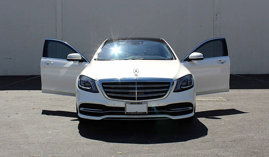 A Mercedes S-Class parked in a lot, showcasing its sleek design and enhanced with ceramic window tint for added privacy.