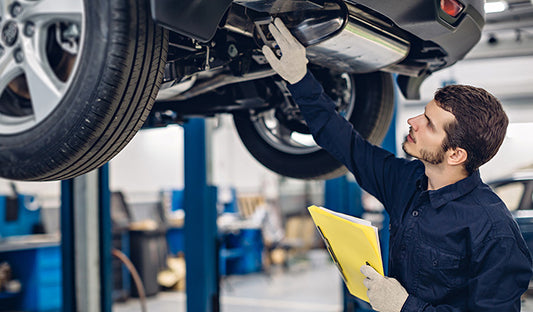 A Man Holding A Clipboard Inspects A Car, Demonstrating Care,car Maintenance, And Innovative Car Care