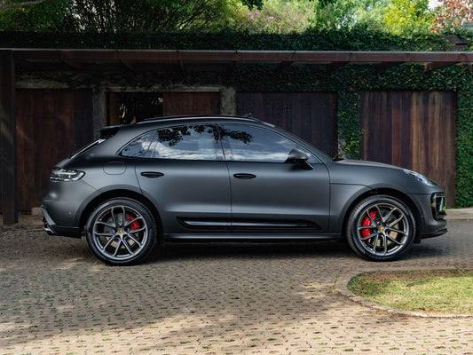 The latest Porsche Macan SUV is parked outside a garage highlighting its stylish exterior and sporty appeal