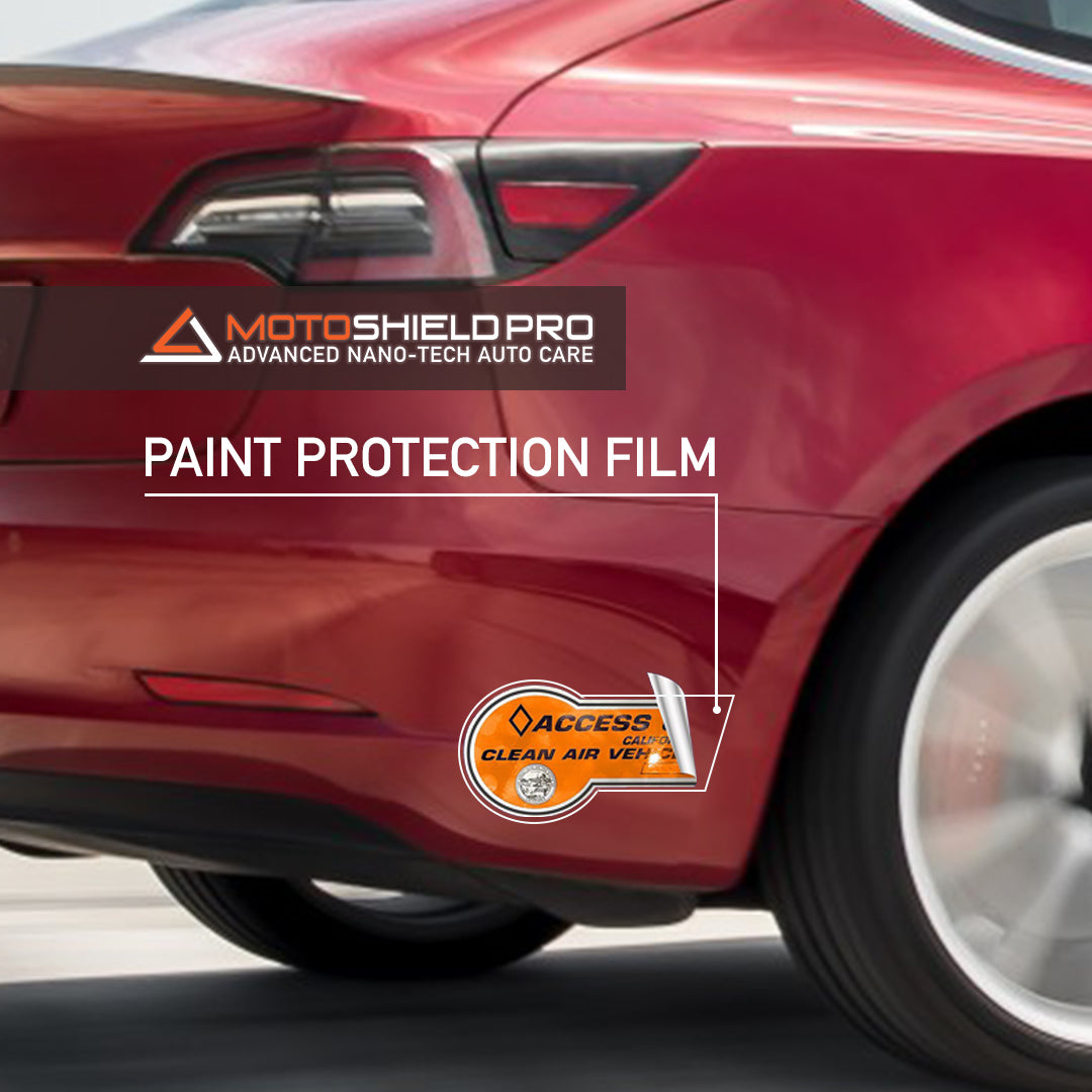 Protective film on rear bumper of red Tesla car.
